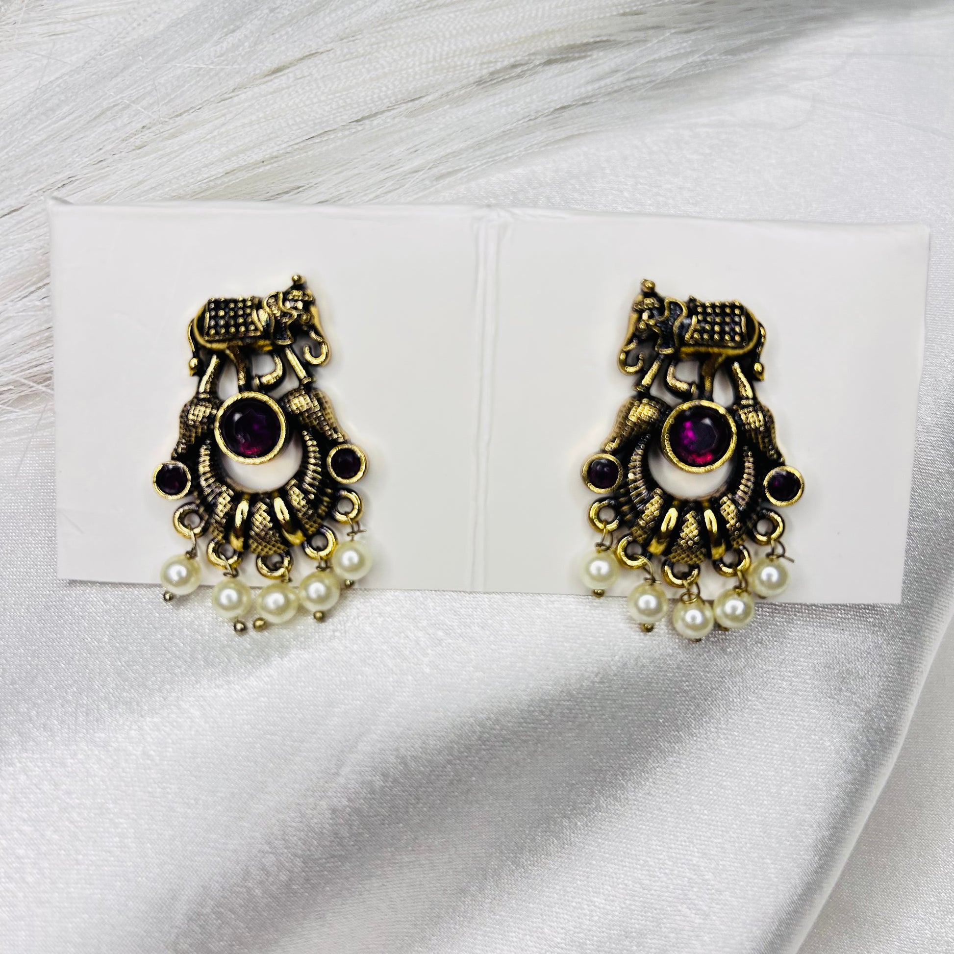Pair of ornate earrings with pearls and gemstones, elephant-shaped, small golden ethnic pink stud earrings